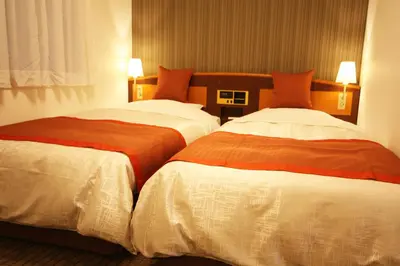 two beds sitting next to each other in a hotel room at Hotel New Ueno in Tokyo