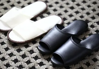 a pair of black slippers and a pair of white shoes at APA Hotel Asakusabashi Ekimae in Tokyo