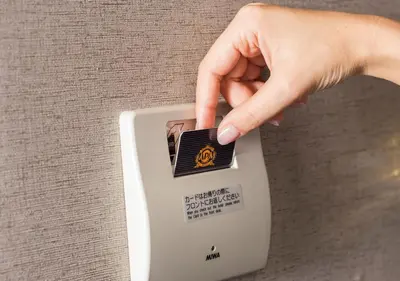 a hand is pushing a button on a lightswitch at APA Hotel Asakusabashi Ekimae in Tokyo