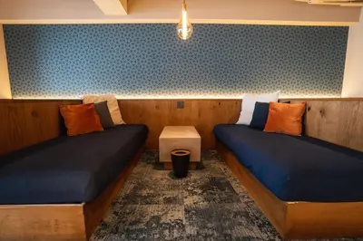 a room with two beds and a table at SAUNALAND ASAKUSA in Tokyo