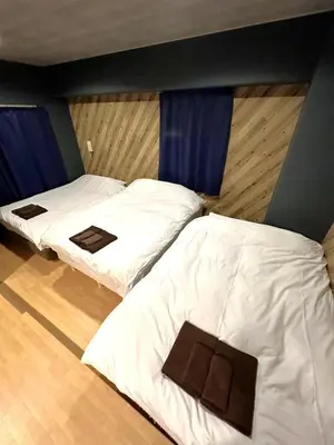 two beds in a room with blue curtains at Green House Nakano Fujimicho - Vacation STAY 66008v in Tokyo