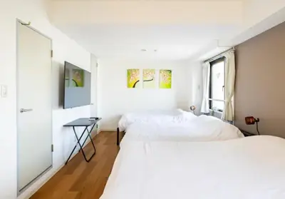 two beds in a room with white walls and a window at Green House Nakano Fujimicho - Vacation STAY 65981v in Tokyo