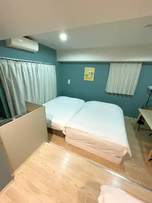 a bedroom with two beds in a room with blue walls at Green House Nakano Fujimicho - Vacation STAY 65992v in Tokyo