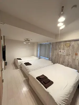 a hotel room with three beds and a television at Green House Nakano Fujimicho - Vacation STAY 65988v in Tokyo