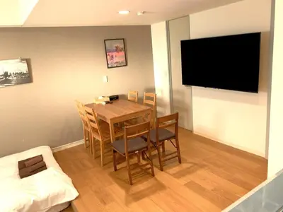 a dining room with a table and chairs and a flat screen tv at Green House Nakano Fujimicho - Vacation STAY 65983v in Tokyo