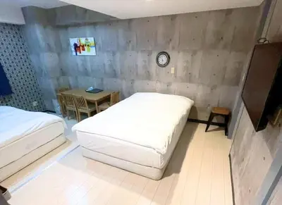 a bedroom with two beds and a table with a clock at Green House Nakano Fujimicho - Vacation STAY 65976v in Tokyo