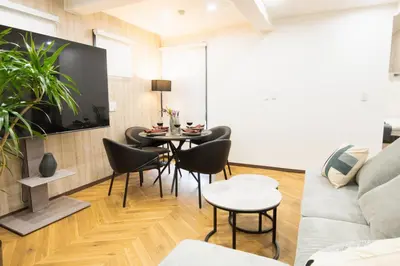 a living room with a couch and a table and chairs at URBAN STAY SHINJUKU EAST - Vacation STAY 67858v in Tokyo