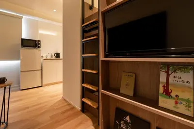 a living room with a flat screen tv on a wall at COCOSHUKU Asakusa Kuramae in Tokyo