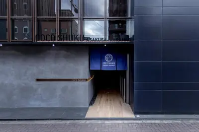 a hallway to a building with a blue sign on it at COCOSHUKU Asakusa Kuramae in Tokyo
