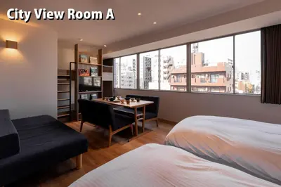 a bedroom with a bed and a desk and a window at COCOSHUKU Asakusa Kuramae in Tokyo