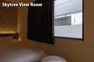 a bedroom with a bed and a window at COCOSHUKU Asakusa Kuramae in Tokyo