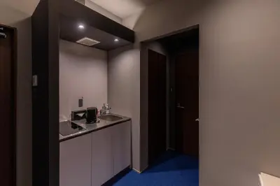 a room with a kitchen with a sink and a counter at COCOSHUKU Shinjuku-Hanazono in Tokyo