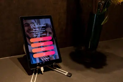 a tablet computer sitting on a table with pink sticks at COCOSHUKU Shinjuku-Hanazono in Tokyo