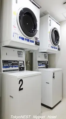 a laundry room with two washing machines on shelves at TokyoNEST Nippori in Tokyo