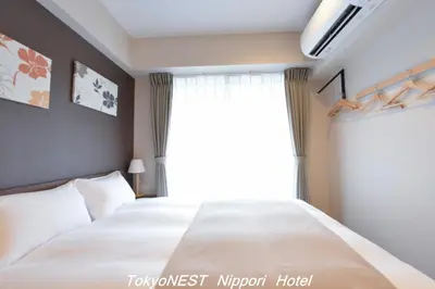 a bedroom with a large bed and a window at TokyoNEST Nippori in Tokyo
