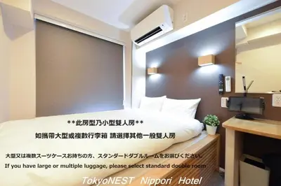 a room with a bed with a large window at TokyoNEST Nippori in Tokyo