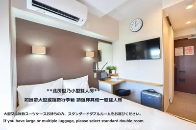 a hotel room with a bed and a clock on the wall at TokyoNEST Nippori in Tokyo