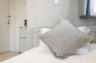 a pillow sitting on top of a bed with white pillows at ZAITO Tokyo Mukojima Hotel \u62bc\u4e0a\u99c5\u5f92\u6b69\u4e03\u5206\u30db\u30c6\u30eb in Tokyo