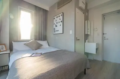 a bedroom with a large bed with a window at ZAITO Tokyo Mukojima Hotel \u62bc\u4e0a\u99c5\u5f92\u6b69\u4e03\u5206\u30db\u30c6\u30eb in Tokyo