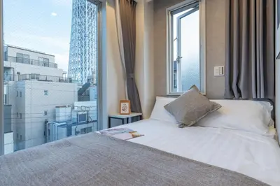 a bedroom with a bed and a large window at ZAITO Tokyo Mukojima Hotel \u62bc\u4e0a\u99c5\u5f92\u6b69\u4e03\u5206\u30db\u30c6\u30eb in Tokyo