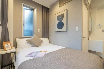 a bedroom with a bed with a book on it at ZAITO Tokyo Mukojima Hotel \u62bc\u4e0a\u99c5\u5f92\u6b69\u4e03\u5206\u30db\u30c6\u30eb in Tokyo