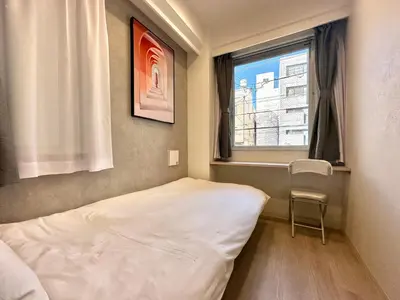 a small room with a bed and a window at ZAITO Tokyo Mukojima Hotel \u62bc\u4e0a\u99c5\u5f92\u6b69\u4e03\u5206\u30db\u30c6\u30eb in Tokyo