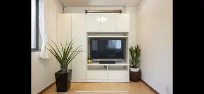 a living room with a tv in a white cabinet at \u7530\u7aef\u6c11\u6cca\u30fc\u7530\u7aef\u30cf\u30a6\u30b9 in Tokyo