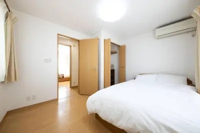 a bedroom with a white bed and a wooden floor at \u7530\u7aef\u6c11\u6cca\u30fc\u7530\u7aef\u30cf\u30a6\u30b9 in Tokyo
