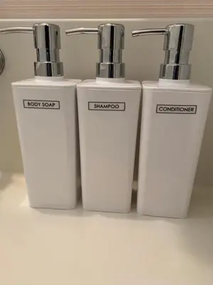 three white bottles sitting next to each other on a shelf at \u7530\u7aef\u6c11\u6cca\u30fc\u7530\u7aef\u30cf\u30a6\u30b9 in Tokyo