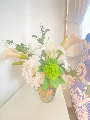 a vase filled with white flowers sitting on a table at \u7530\u7aef\u6c11\u6cca\u30fc\u7530\u7aef\u30cf\u30a6\u30b9 in Tokyo