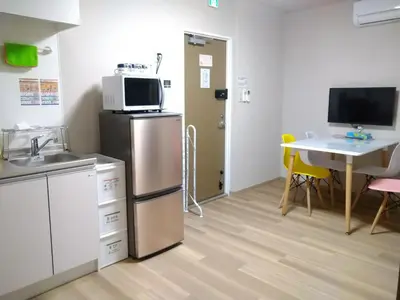 a kitchen with a refrigerator and a table with chairs at Hitoyado Ryokan Higashiueno - Vacation STAY 72556v in Tokyo