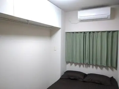 a bedroom with a bed and a green curtain at Hitoyado Ryokan Higashiueno - Vacation STAY 72552v in Tokyo