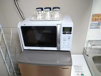 a white microwave sitting on top of a refrigerator at Hitoyado Ryokan Higashiueno - Vacation STAY 72541v in Tokyo