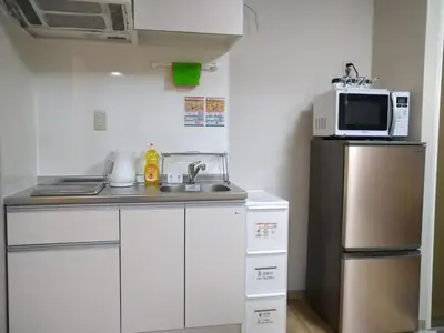 a small kitchen with a microwave and a refrigerator at Hitoyado Ryokan Higashiueno - Vacation STAY 72546v in Tokyo