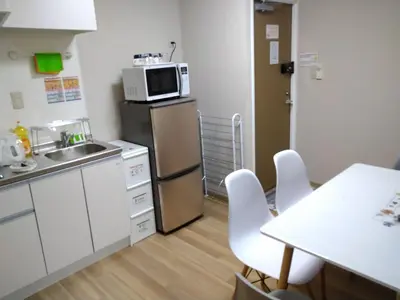 a kitchen with a refrigerator and a table and chairs at Hitoyado Ryokan Higashiueno - Vacation STAY 72534v in Tokyo