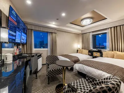 a hotel room with two beds and a flat screen tv at APA Hotel Ueno Ekiminami in Tokyo
