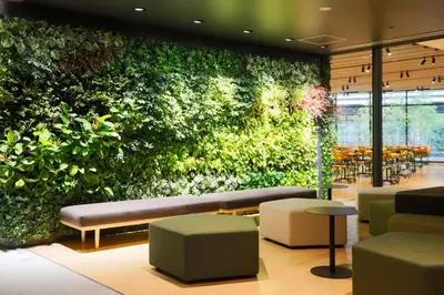 a green wall in a restaurant with a bench and chairs at L stay & grow Minami Sunamachi in Tokyo