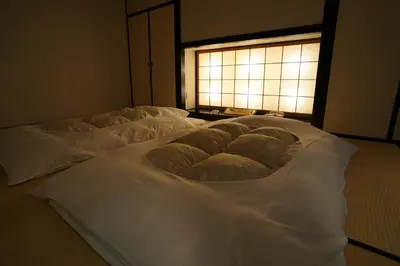 two beds with white sheets in a room with a window at Asakusa Central Hotel in Tokyo
