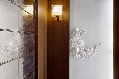 a hallway with a door with a chandelier on the wall at Andaz Tokyo - A Concept by Hyatt in Tokyo