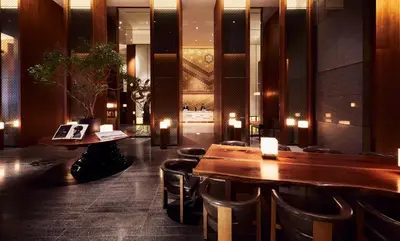 a restaurant with wooden tables and leather chairs at Andaz Tokyo - A Concept by Hyatt in Tokyo