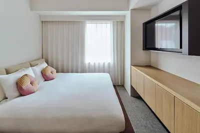 a hotel room with a bed and a flat screen tv at OMO3 Tokyo Akasaka by Hoshino Resort in Tokyo