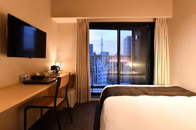 a hotel room with a bed and a desk and a window at FL Hotel Asakusa in Tokyo