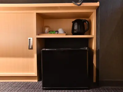 a black refrigerator sitting inside of a cabinet at FL Hotel Asakusa in Tokyo