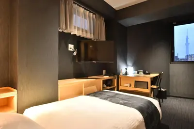 a hotel room with a bed and a flat screen tv at FL Hotel Asakusa in Tokyo