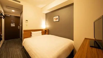 a bedroom with a white bed and a television at Via Inn Shinagawa Oimachi in Tokyo