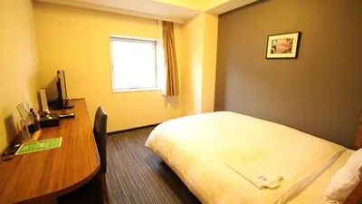a hotel room with a bed and a desk at Via Inn Shinagawa Oimachi in Tokyo