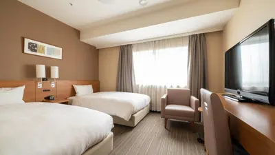 a hotel room with two beds and a flat screen tv at Via Inn Shinagawa Oimachi in Tokyo