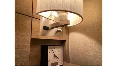 a hotel room with a clock and a light at Via Inn Higashi-Ginza in Tokyo