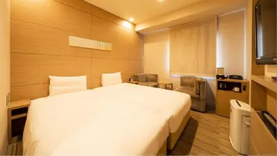 a bedroom with a large white bed in a room at Via Inn Higashi-Ginza in Tokyo