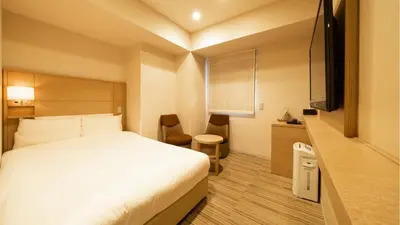 a hotel room with a bed and a flat screen tv at Via Inn Higashi-Ginza in Tokyo
